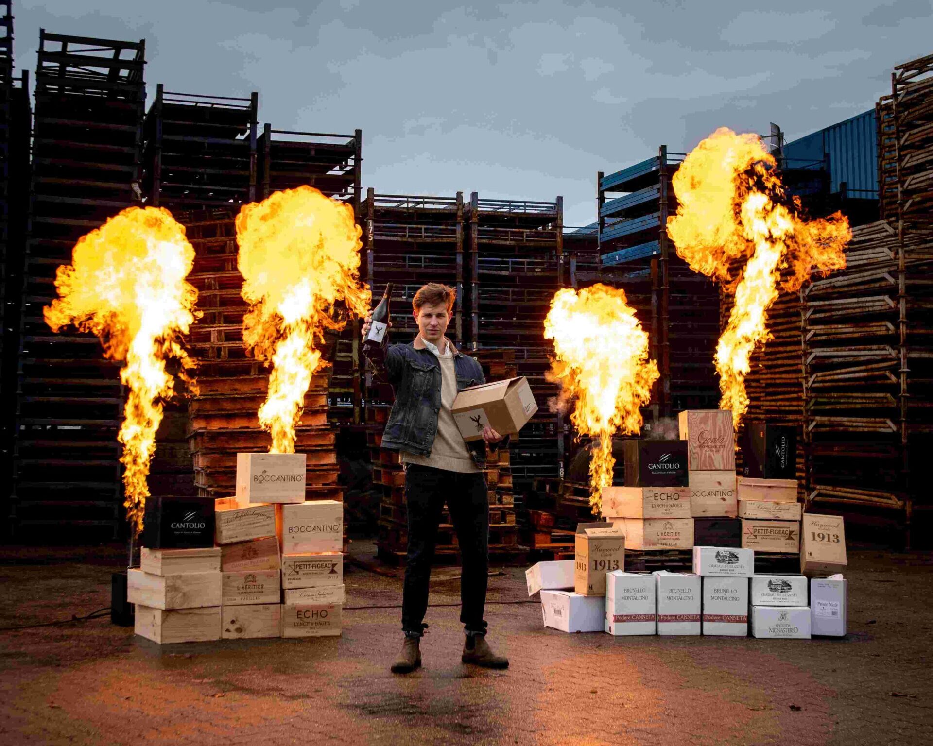 Den Sidste Flaske founder Tobias Hinchely Pedersen with wine and flame towers